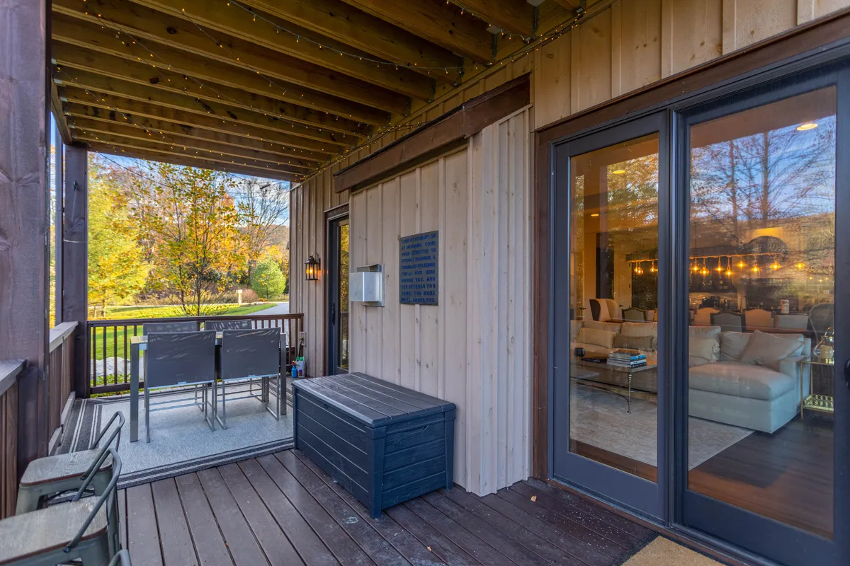 This image features an inviting outdoor seating area with comfortable furnishings, a decorative lantern, and a view of the lush garden. The scene evokes a sense of relaxation and togetherness, ideal for enjoying fresh mountain air and al fresco meals under the open sky.