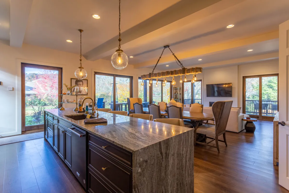 A bright kitchen and dining area with a spacious island and large windows, this scene encapsulates the heart of group gatherings—whether cooking, dining, or planning the next adventure. The inviting setup encourages memorable holiday meals or summer barbecues.